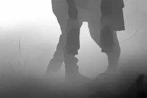 Silhouetted legs of a person standing in a foggy environment, with a slightly bent knee. The background is obscured by the dense fog.